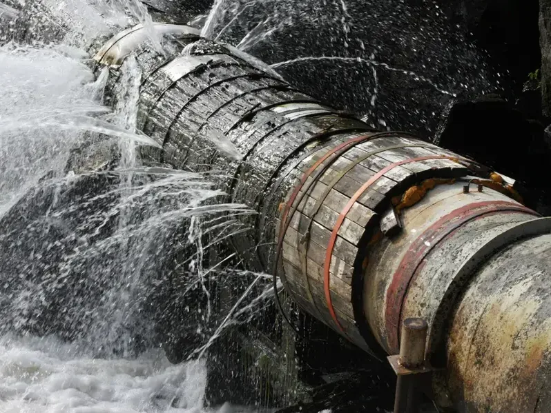 Water sprays from a broken joint on a damaged pipe
